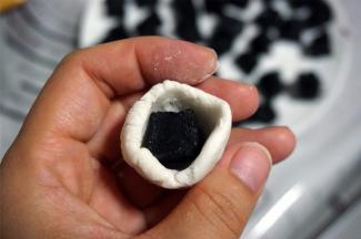 包裹馅料前，将小面团揉光滑，然后拍上干粉，捏出一个窝，放入馅料，包好揉圆。