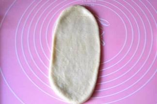 100g面团用擀面杖擀成椭圆形