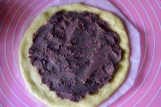 底下垫张油纸，把圆形面片放到上面，抹上一层豆沙，边上留一点距离不要抹，然后再放上第二片，再抹上豆沙，重复上面步骤把第三片盖到上面