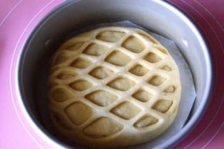 拉开，铺到面片上面，然后放到8寸圆模内
放入烤箱进行2次发酵，发酵至2倍大（这里讲究湿度和温度）记得烤箱里放碗热水
发酵好后表面刷一层蛋液，烤箱预热180度，下层，上下火170度 25分钟左右