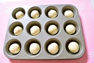 发酵好的的面团进行排气，称重
用刮板将面团平均分成12份面团，滚圆后放入连摸中