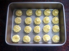 在9寸长方形不粘饼盘上挤出曲奇坯。