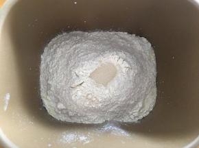 将面包材料除黄油以外的全部放入面包机，开启和面程序10分钟