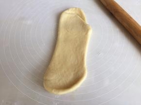取其中一个面团，揉，再次擀成牛舌状；