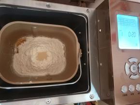 将除黄油以外的食材，以先液体后分类的顺序放入面包集中，选择和面程序，时间设置成20分钟