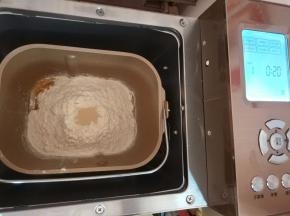 将除黄油以外的食材，以先液体后分类的顺序放入面包集中，选择和面程序，时间设置成20分钟