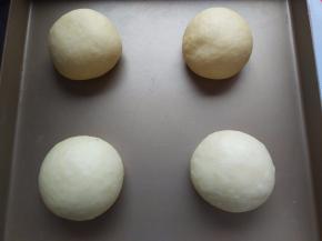 取出面团，排气后，分成4等分，放在烤箱中，加一碗热水，打开发酵功能，开始二次发酵