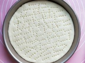 将披萨盘刷一层黄油(食用油也行 )，把面团放盘子中，用叉子扎孔，尽量扎通透。多余的面团扎好孔后，放烤箱170°烤五分钟取出放凉，装入食品袋放进冰箱冷冻，随吃随取