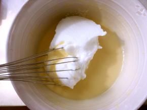 将打发好的蛋白分次加入到蛋黄糊中翻拌均匀