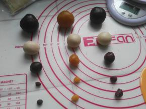 另外称出台式桃山皮、咖啡桃山皮、绿茶桃山皮、紫芋味桃山皮各46克，其中各40克作为馅料、5克用来制作小企鹅的头顶、1克用来制作小企鹅的小手；牛奶桃山皮40克，均分成四份用来制作小企鹅的身体；分别搓圆待用（图中不含绿色小企鹅的料），按同样的方法做出紫色、黄色、咖啡色小企鹅