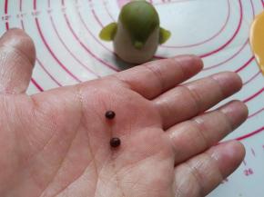 用咖啡桃山皮搓成两个很小的圆面团用来制作小企鹅的两个小眼睛（见图）