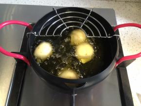 油炸锅内倒入花生油，油热到一伸进去筷子会冒泡就放下土豆丸子，一边炸一边翻