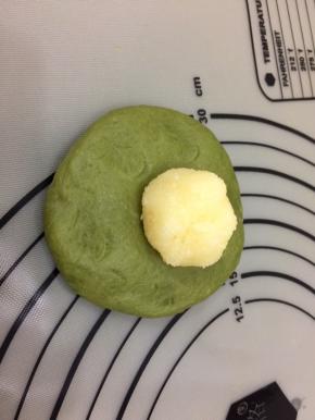 饧好的面团，按成圆形，中间厚四周薄，将馅料放入