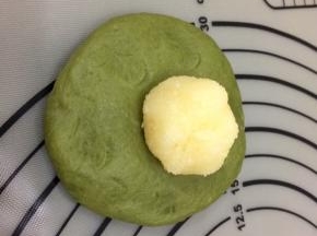 饧好的面团，按成圆形，中间厚四周薄，将馅料放入