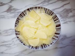 切好的土豆片放入盘子里，冷水冲洗两遍，洗掉淀粉，再用清水泡5分钟。