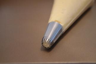 准备一个18齿的裱花嘴，装入裱花袋，将曲奇面糊装入裱花袋内