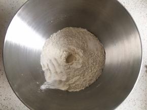 高筋面粉与黑麦粉混合均匀，中间挖一小孔，倒入活性干酵母粉，盐和糖对角线放置