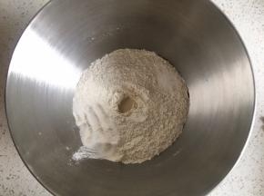 高筋面粉与黑麦粉混合均匀，中间挖一小孔，倒入活性干酵母粉，盐和糖对角线放置