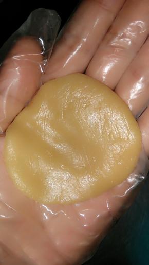 把面团放在手上按平，放上包好蛋黄的内陷。