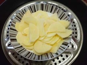 切好的土豆片放入锅中，隔水蒸熟，约8-10分钟即可。