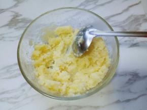 取出蒸熟的土豆，放入大口的容器里，趁热加入黄油，少许盐，用汤勺碾成土豆泥。