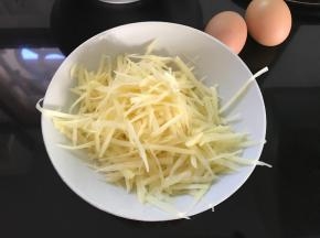 再把土豆用擦丝器擦成丝。