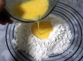 低筋粉，高筋粉，泡打粉混合过筛到揉面垫上，然后中间挖空，倒入全蛋液。