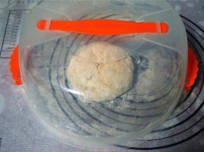 在面团表面撒上少许玉米淀粉，揉圆，盖上盖子，静置松弛15分钟。