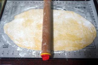 在面团上撒上玉米淀粉防粘，然后擀成0.2厘米厚的薄片。