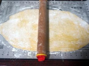 在面团上撒上玉米淀粉防粘，然后擀成0.2厘米厚的薄片。