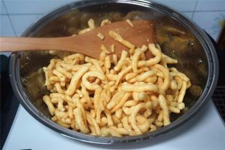 熄火，倒入炸好的坯条，趁热快速翻拌，让每一根坯条都能沾到糖浆。