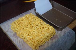 冷却后用刮板从边缘挑起，将沙琪玛倒出模具。