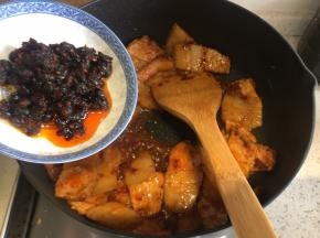 翻炒到五花肉微微卷起，加入豆豉、生抽、料酒、适量砂糖，翻炒均匀
