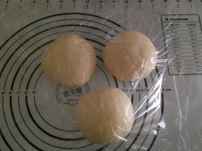 取出面团，排气，平均分成3份，重新揉圆，盖上保鲜膜，静置15分钟。