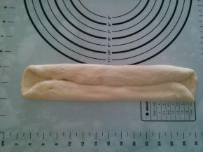 取一个面团，擀长，两边对折，卷起。