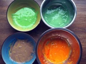 将蛋黄糊平均分成4份，分别加入色素，拌均匀。