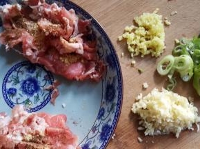 10．准备好葱姜蒜末，切好的羊肉上放入适量的胡椒粉和干姜粉磨。