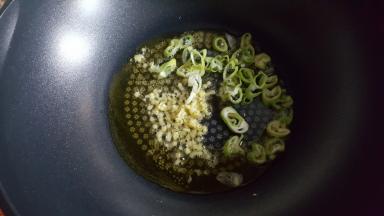 12．大火烧热后，放入葱姜煸炒出香味。