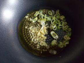 12．大火烧热后，放入葱姜煸炒出香味。