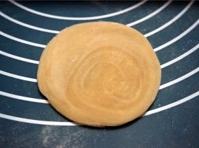 取一块静置的面团擀开。