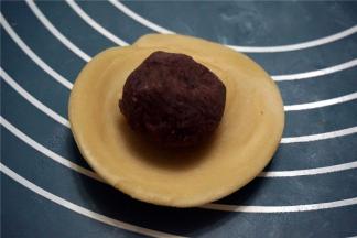 将红豆馅放中间，包起来，收口向下。