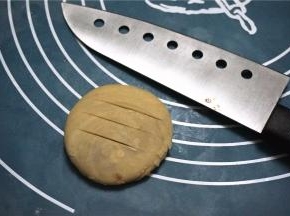 用手压扁，用刀划上三刀。