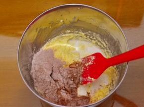 加入一半过筛的粉类和牛奶，用刮刀稍微翻拌混合一下