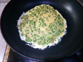 舀入一勺面糊，晃动锅子使其均匀摊开