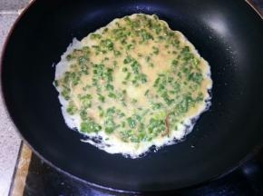 舀入一勺面糊，晃动锅子使其均匀摊开