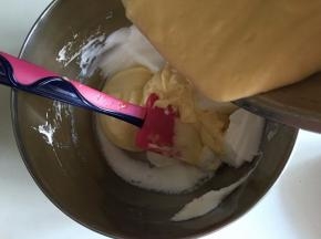 再次加入1/3蛋白霜，此时用刮刀轻轻翻拌均匀，将拌好的蛋糕糊倒回剩下的蛋白霜中，用刮刀由底部像上翻