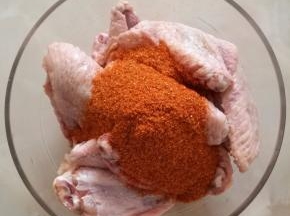 4.奥尔良腌料粉倒在鸡翅里。