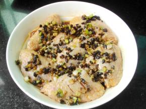 将炒好的小料倒入鸡翅上