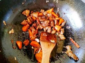 再加入老抽，生抽和料酒翻炒片刻，加入胡萝卜炒均匀。
