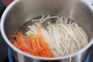 清水煮沸，放入胡萝卜、金针菇汆烫，捞出沥干水；